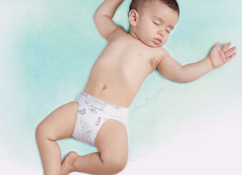 Un bebé durmiendo de espaldas, con un pañal Dodot. Un bebé durmiendo de espaldas, con un pañal Dodot.