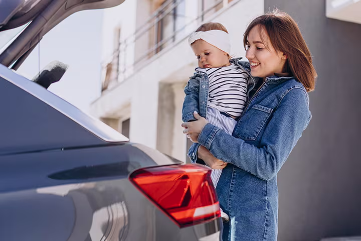 Μητέρα με μωρό αγκαλιά δίπλα σε αυτοκίνητο