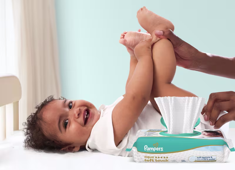 Baby liegt auf dem Rücken und wird sanft mit einem Feuchttuch gereinigt.