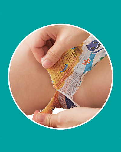 A close-up shot shows a parent’s hands tearing the side of a Baby Shark-themed swim diaper on a baby, highlighting the "Super easy-tear sides" feature.