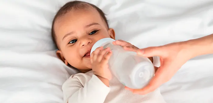 Bebé tomando leche en mamadera.