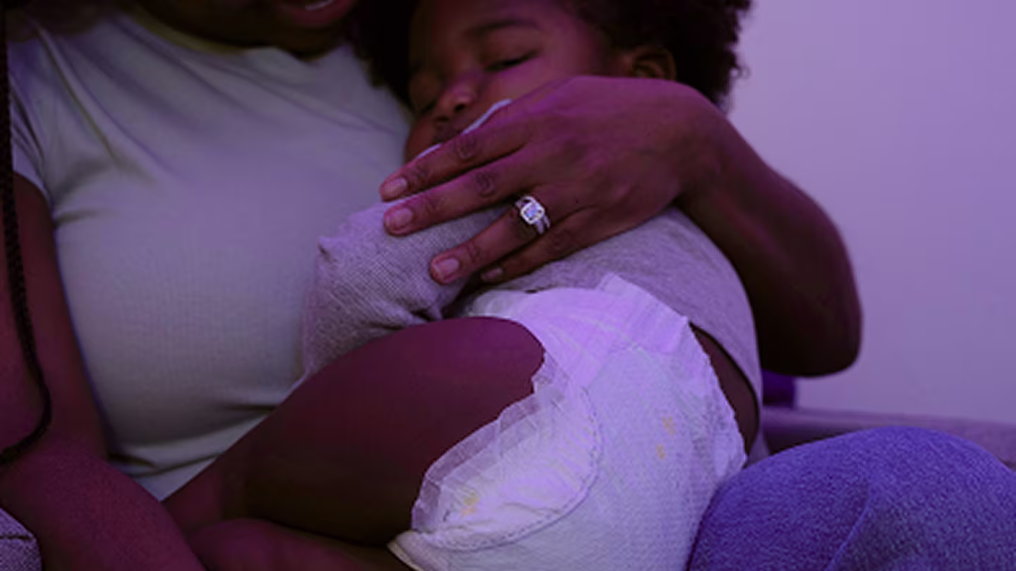 Toddler sleeping on moms lap