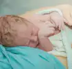 Newborn Baby being swaddled by their mother