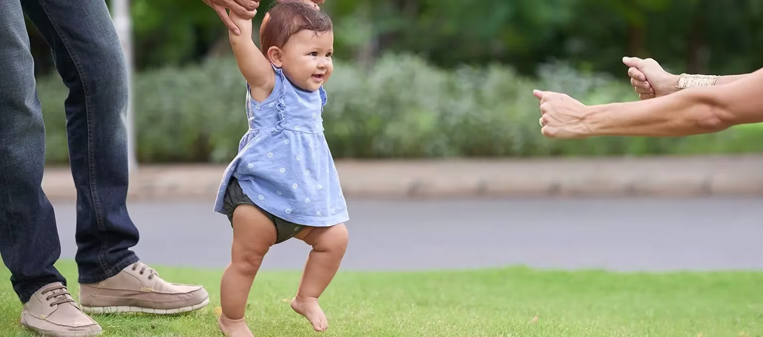 Baby playing in the park with parents