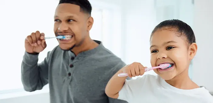 Criança escovando os dentes com o papai Criança escovando os dentes com o papai