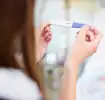 Gros plan d'une femme tenant un test de grossesse dans ses mains