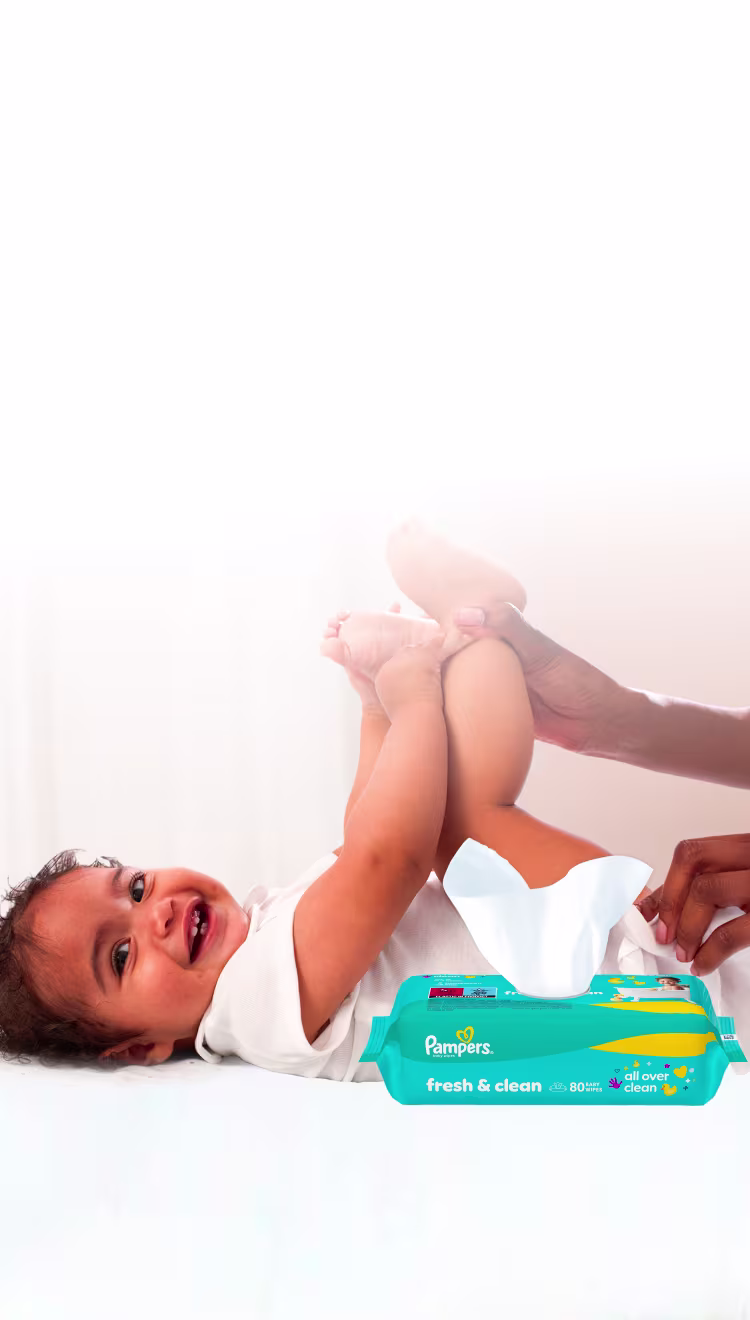 Baby liegt auf dem Rücken und wird sanft mit einem Feuchttuch gereinigt.