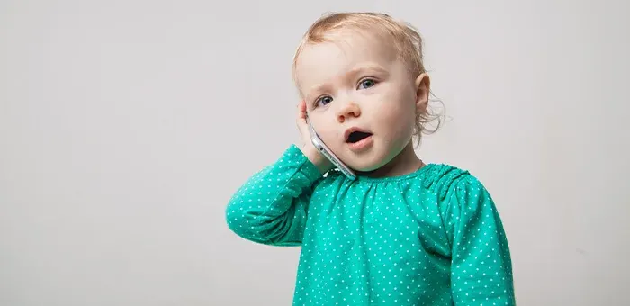 Criança falando no telefone de brinquedo
