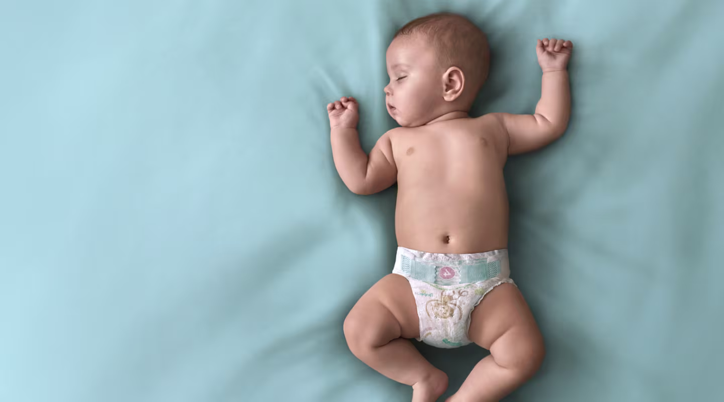 Ένα μωρό με πάνα Pampers κοιμάται ανάσκελα