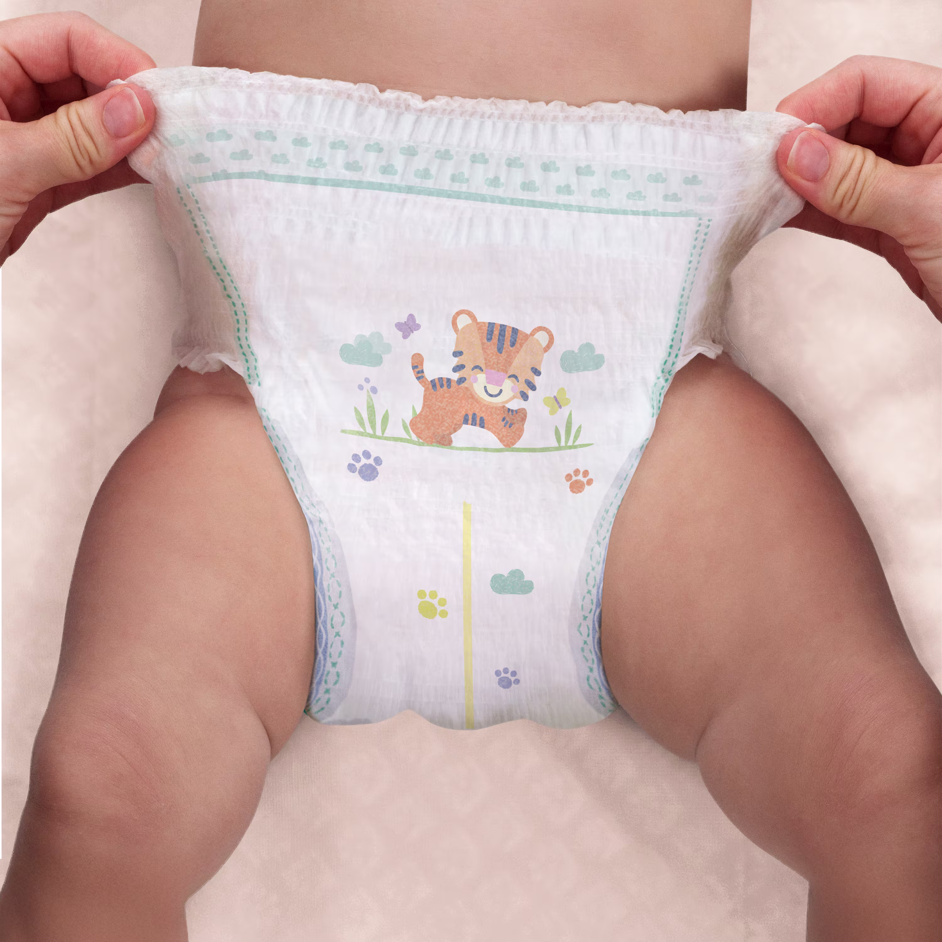 Imagine cu două mâini care trag în sus de scutecul-chiloțel Active Baby Pants. Imagine cu două mâini care trag în sus de scutecul-chiloțel Active Baby Pants.