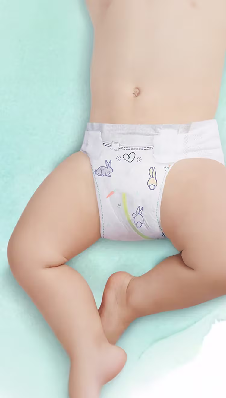 Aussicht eines Oberkörpers und Beine eines Babys, das Pampers Harmonie Windeln trägt. Mit einem Pfeil wird der Urin-Indikator gezeigt.