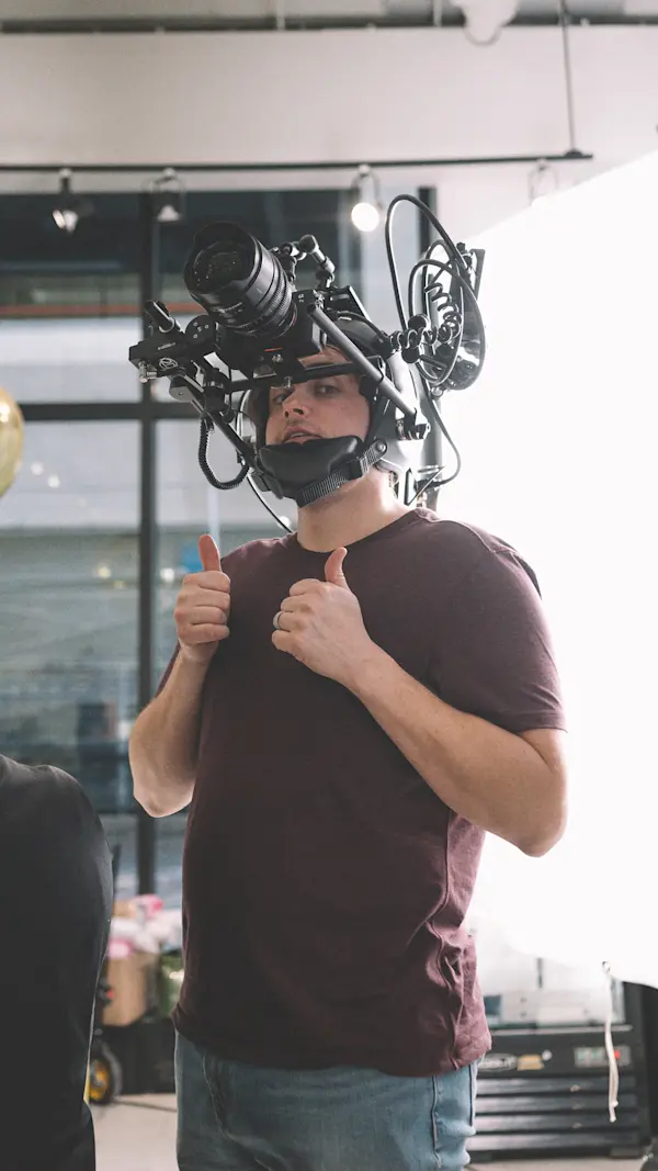 Oak + Rumble crew member wearing the POV helmet camera rig, giving two thumbs up on set.