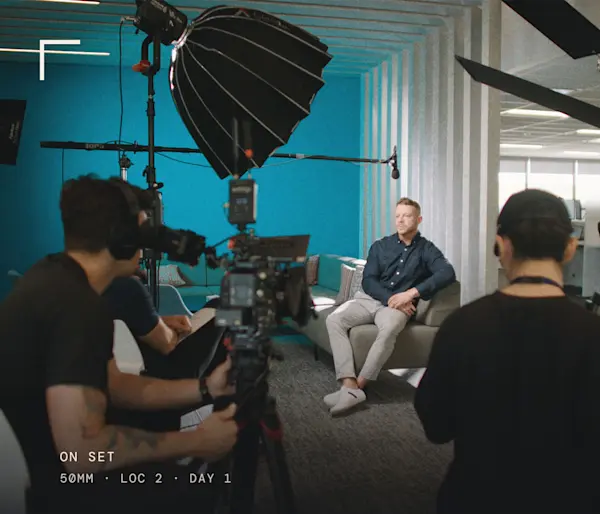 Film crew, cameras and lights set up around an interview chair in Equitable's Waterloo head office