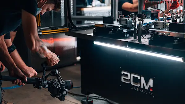 Camera operators filming a 2CM Innovative assembly station with a gimbal-stabilized camera