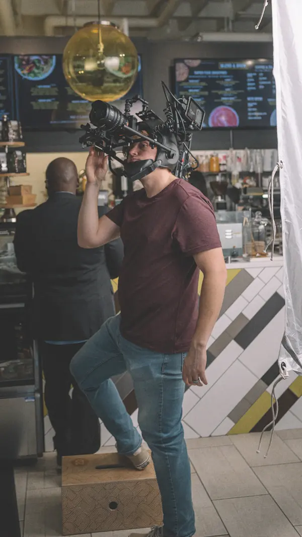 Crew member wearing the POV helmet camera rig with one foot on a box in a juice bar.