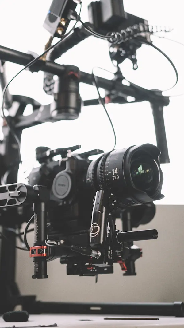 Close-up of a camera with a wide cine lens and follow focus mounted on a gimbal.