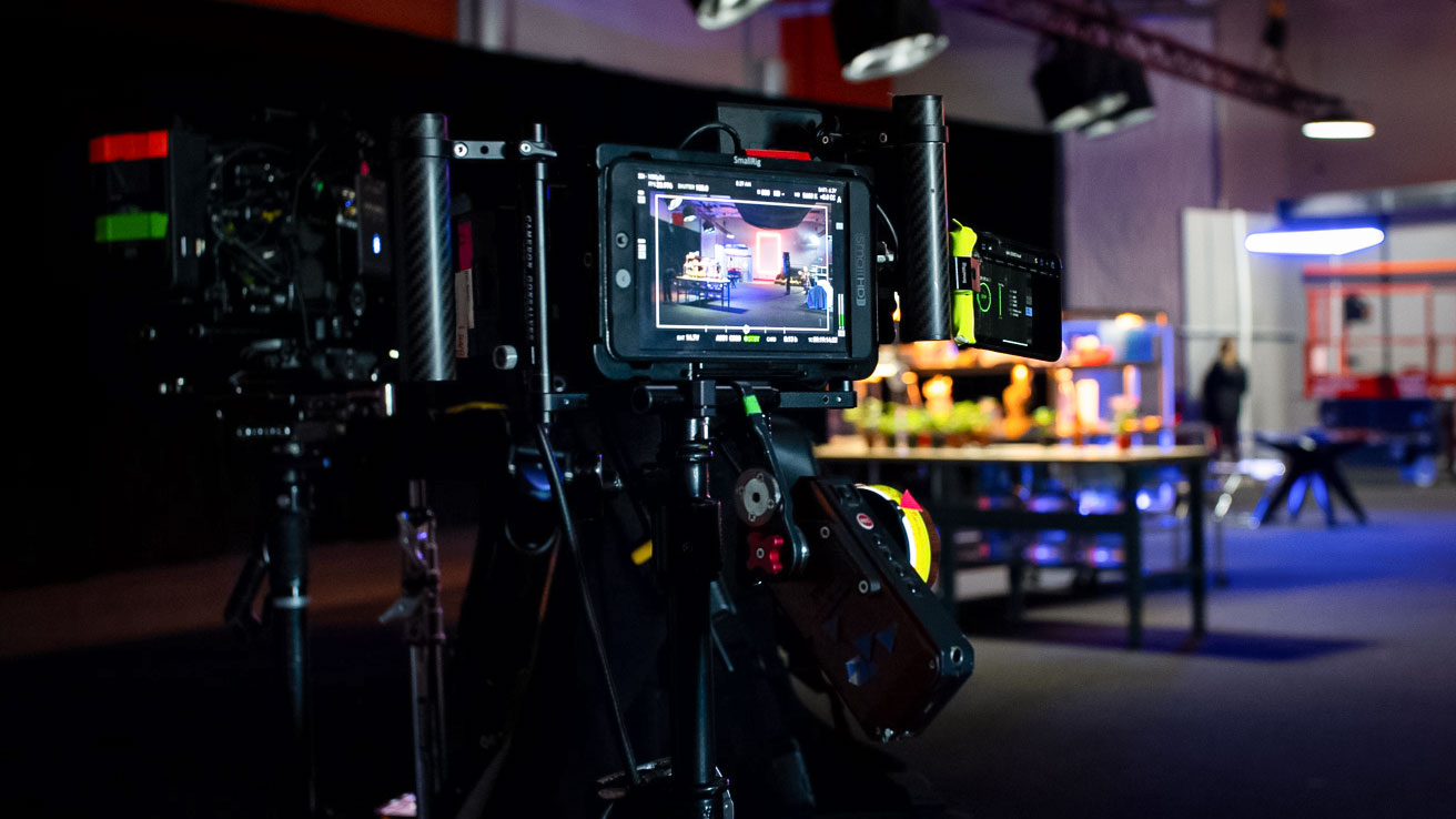 Cinema camera and monitor on set during the Linamar brand film shoot, with studio lights and a lab set behind it.