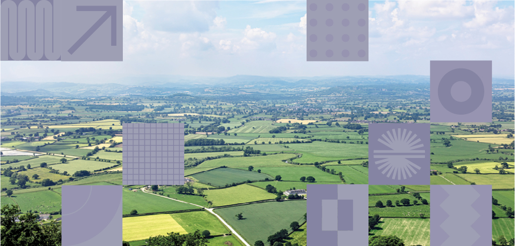 Aerial view of green countryside with patchwork fields, rolling hills, and distant mountains under a blue sky with abstract overlays.