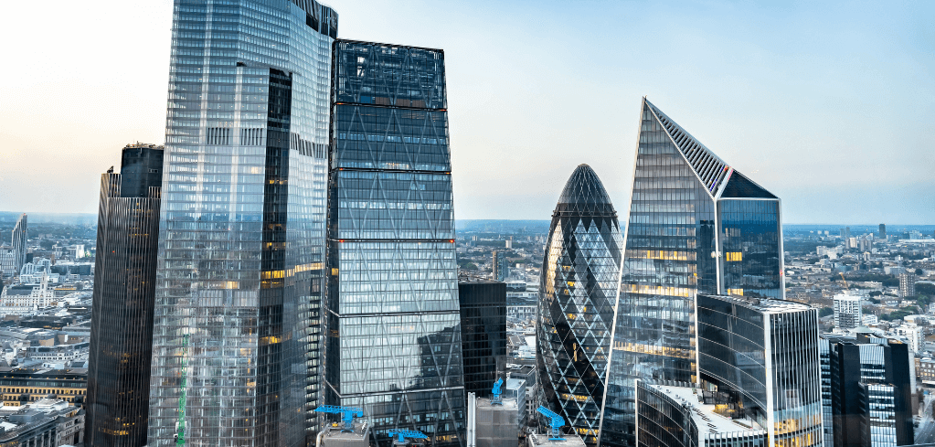 Modern London skyline featuring iconic glass skyscrapers including the Gherkin and other distinctive financial district buildings.