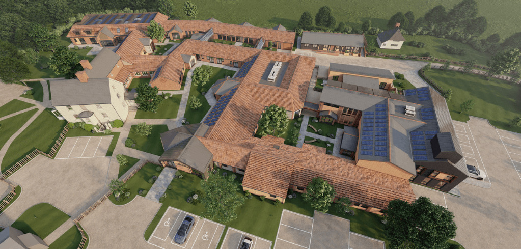 Aerial rendering of a rural building complex with terracotta roofs, solar panels, green lawns, trees, and parking lots.