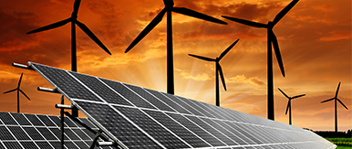 Solar panels and wind turbines set against a dramatic orange sky, highlighting renewable energy technology in a rural landscape.