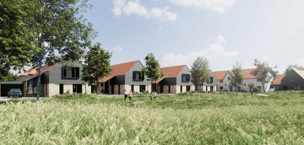 Rendering of modern residential homes with red roofs and stone facades, set behind a lush green meadow under a blue sky.