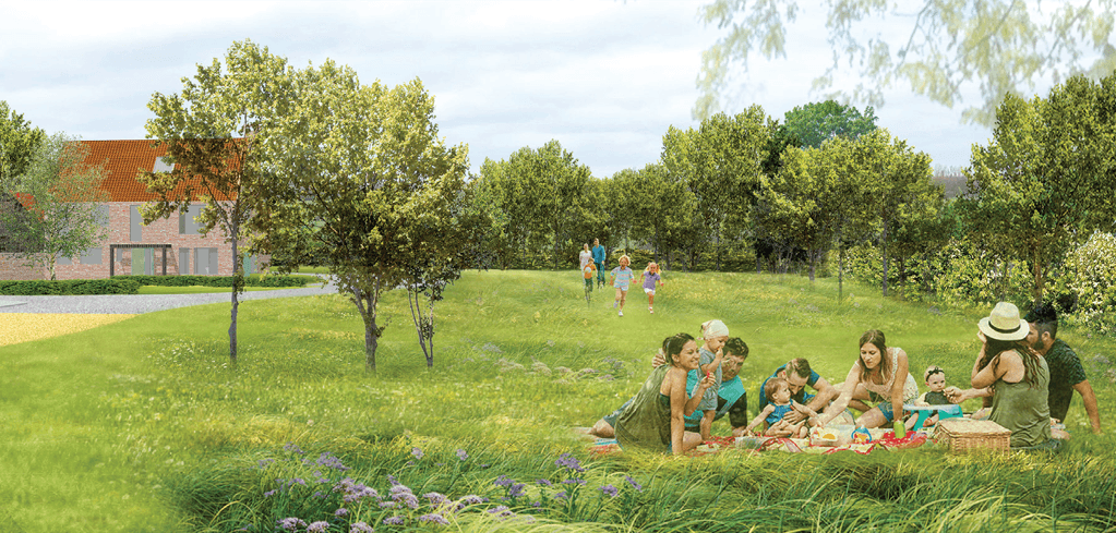 A family enjoys a picnic on green grass while children run nearby, with trees and a brick house in the background.