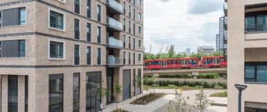 A contemporary residential development set within a thoughtfully designed urban environment. Modern brick-built apartment buildings frame a landscaped courtyard, creating a calm and welcoming space for residents. Excellent transport links run nearby, offering seamless connectivity while maintaining a sense of privacy and community. The development combines high-quality architecture, green spaces and city convenience to support modern living.