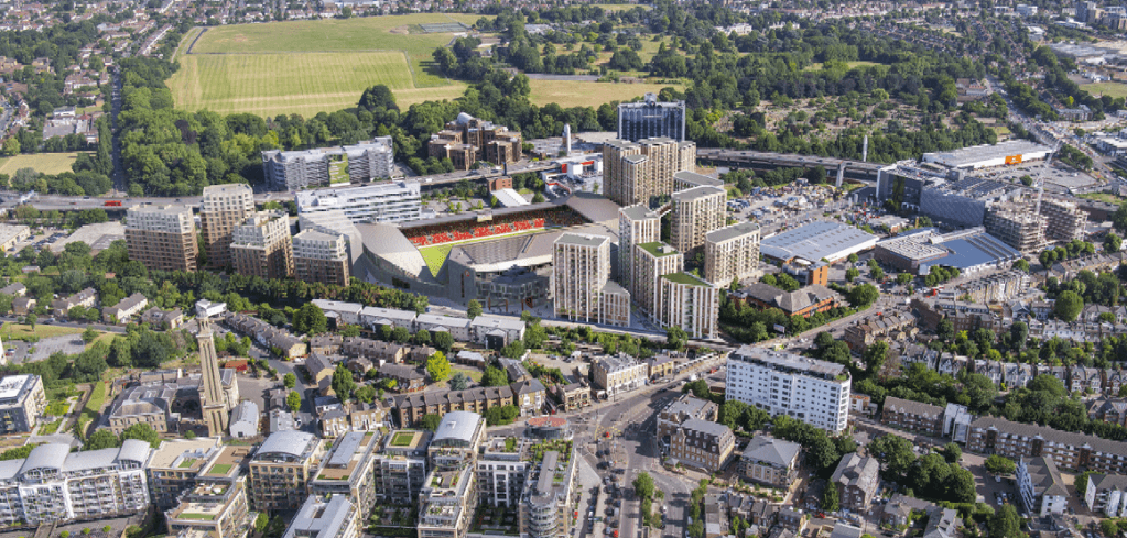 Aerial view of urban development with stadium complex surrounded by apartment buildings, green parks and residential areas.