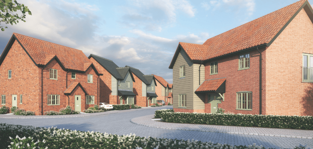 New residential development with red brick homes, terracotta roofs, and landscaped gardens lining a curved paved street.