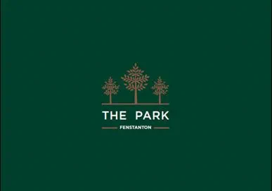 Green logo for "THE PARK" at Fenstanton featuring three gold stylized trees above white text