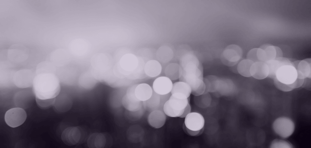 Abstract black and white image with blurred circular light bokeh creating a dreamy, soft-focus background.