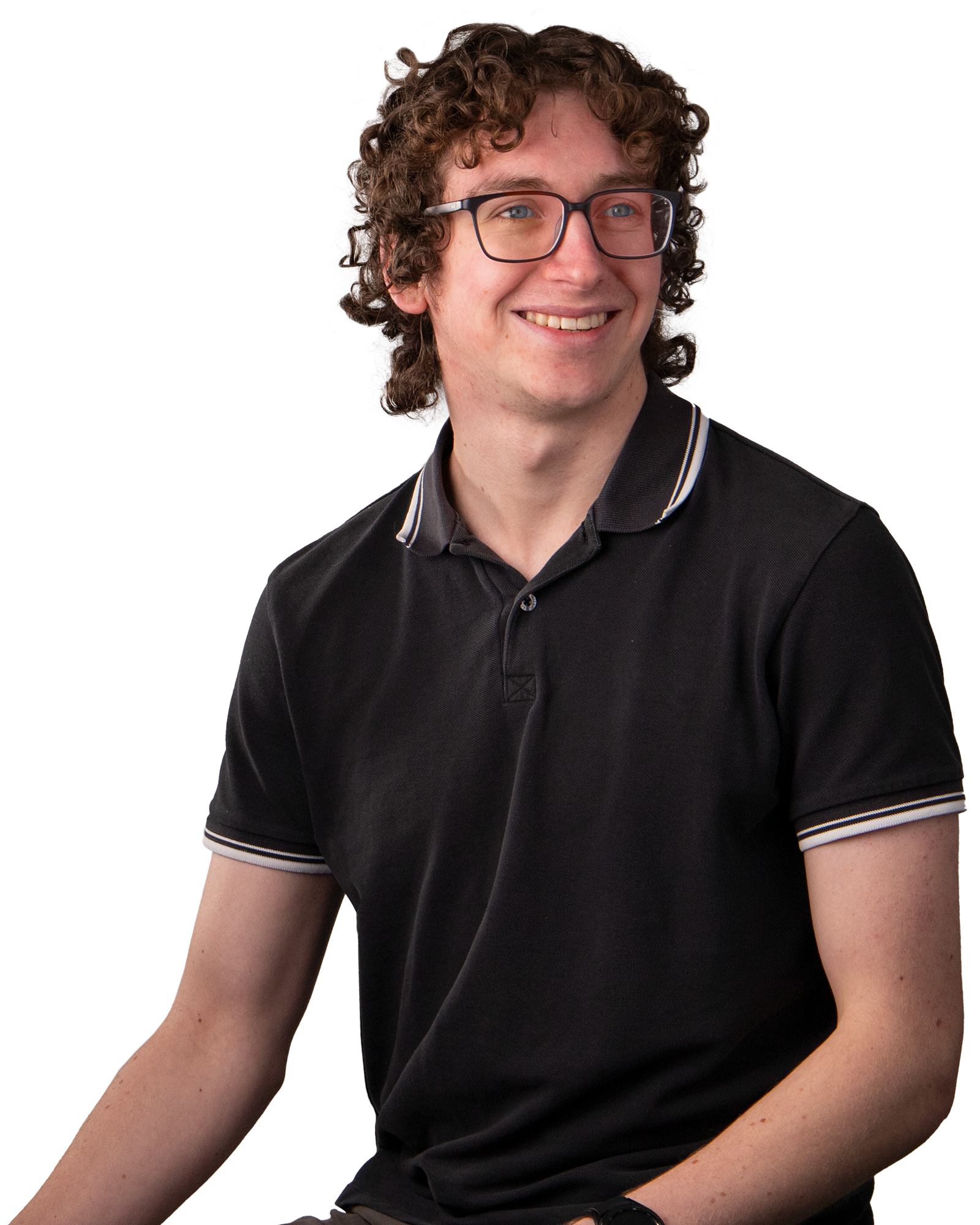 Man with curly brown hair, glasses, smiling.