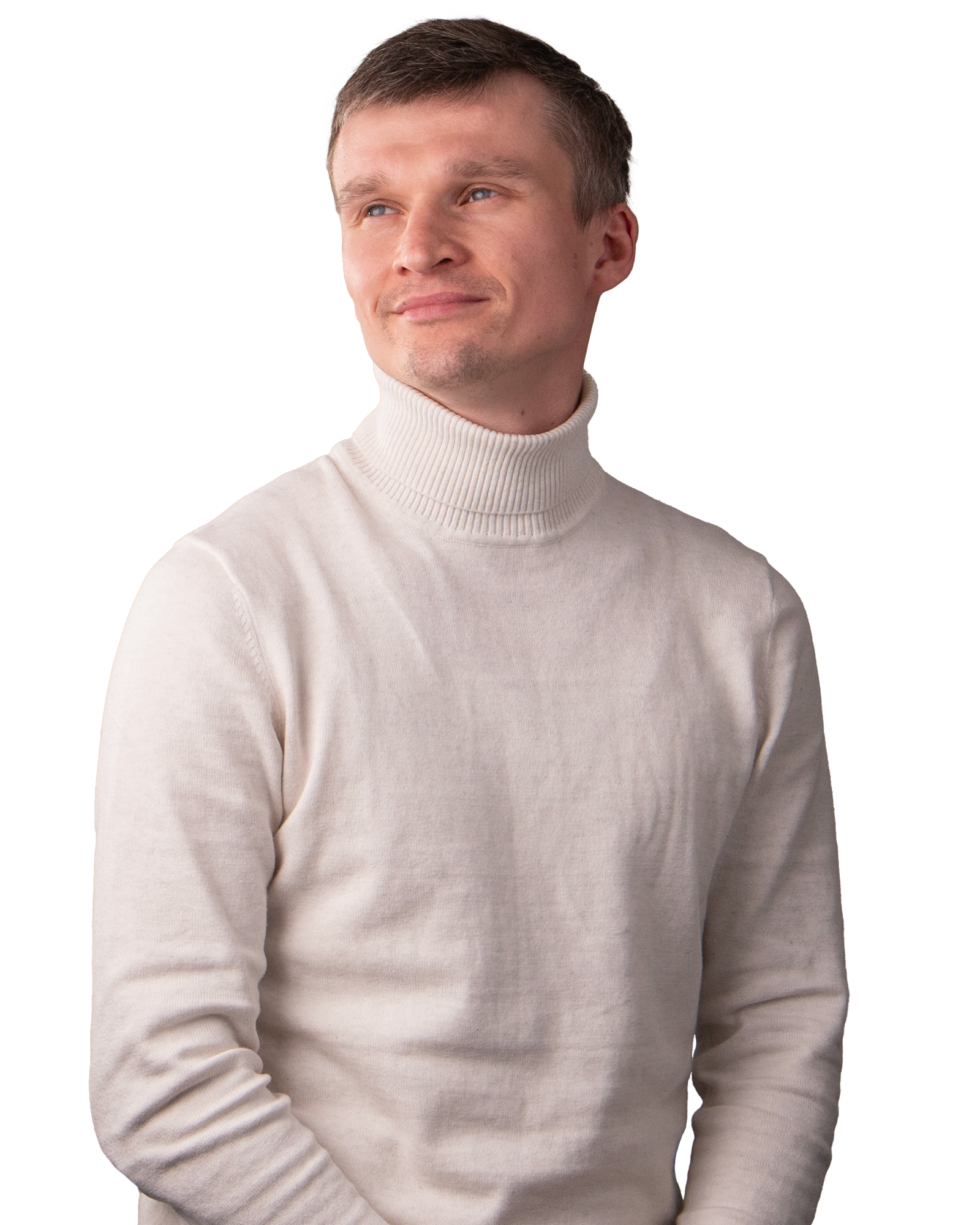 A man wearing a white long sleeved turtle neck sweater. Smiling.