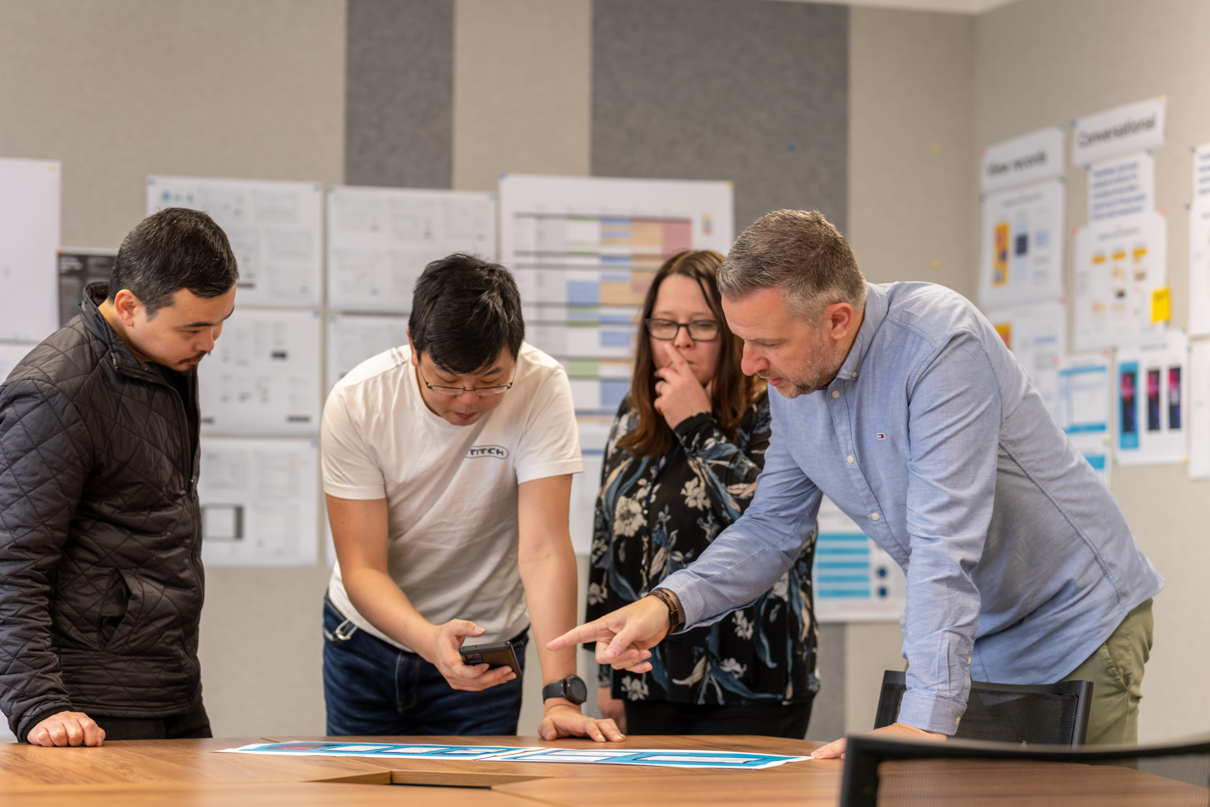 Four people looking at documents on a table