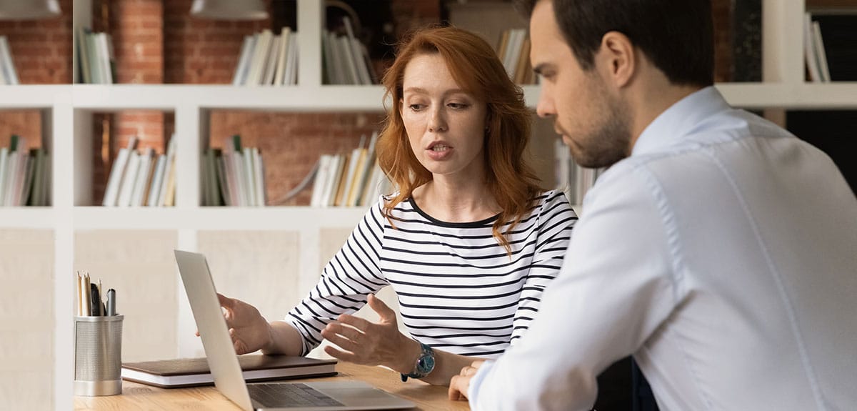 Mulher a falar com homem ao computador