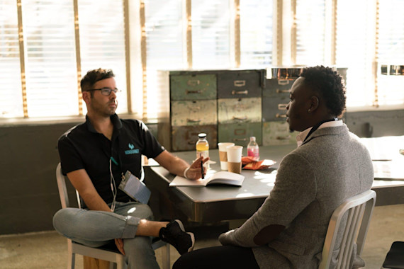 dois homens a fazer uma entrevista de emprego vestidos de forma casual.