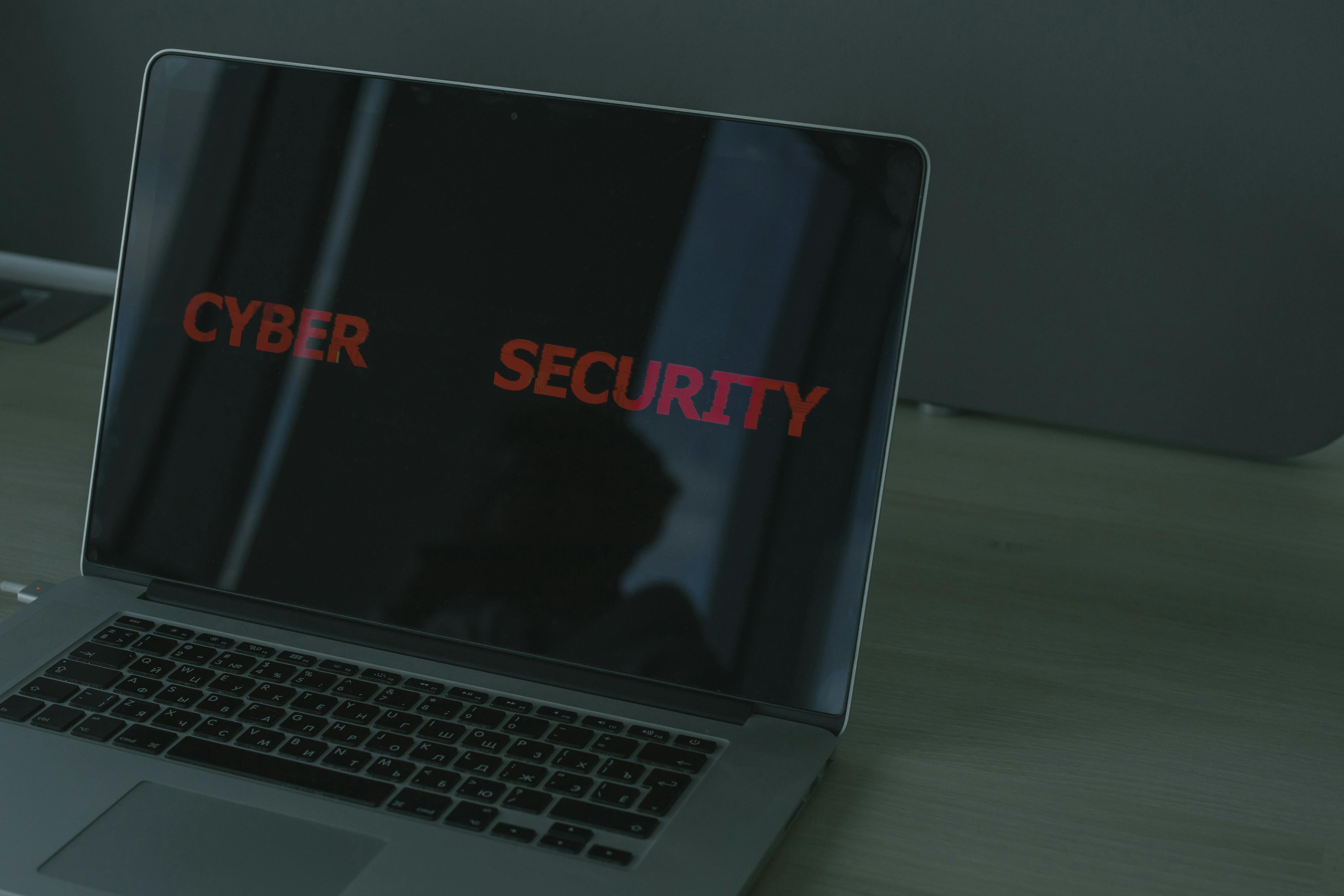 Portátil sobre uma secretária com a expressão “Cyber Security” visível no ecrã.