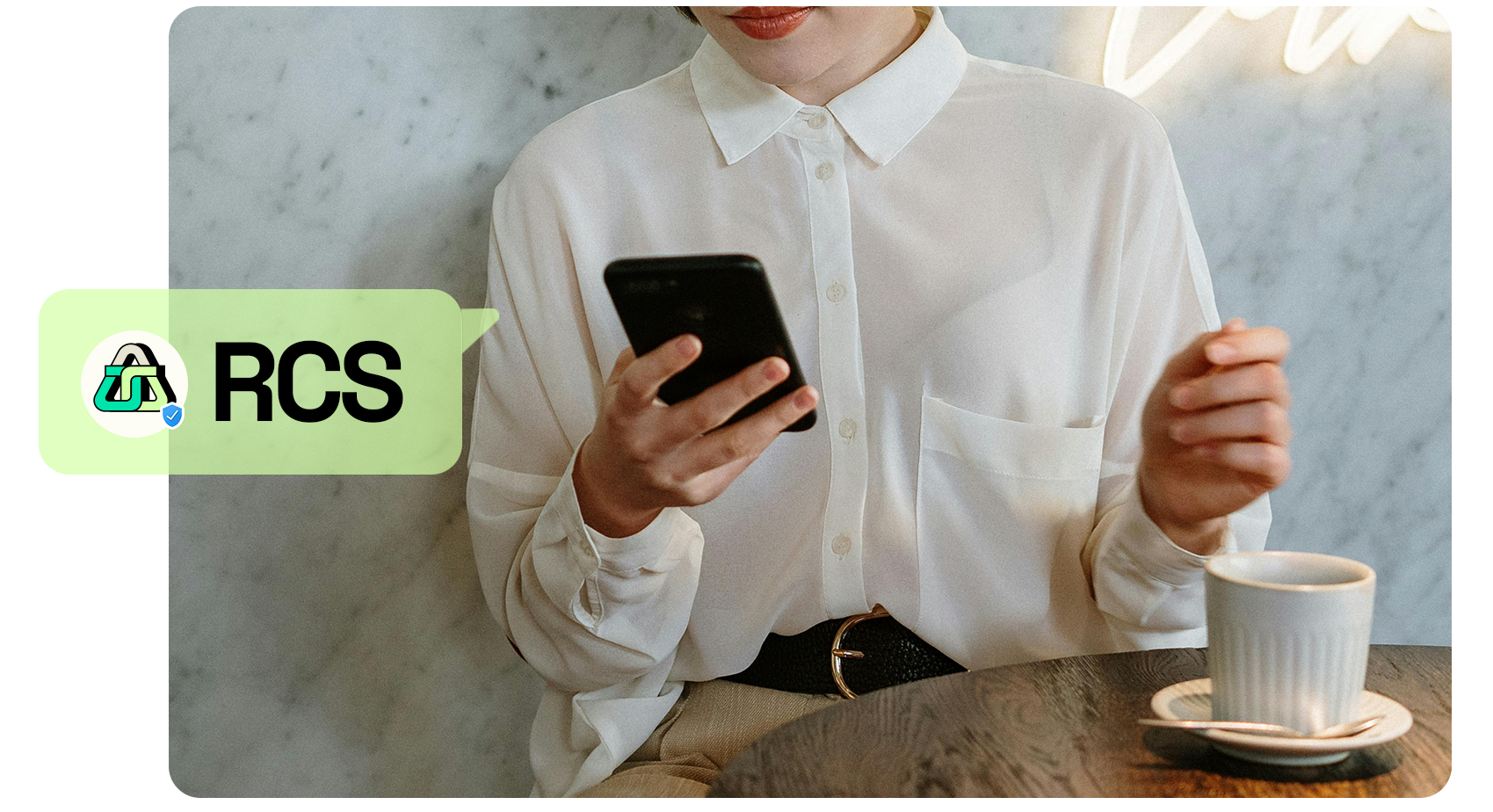 RCS image person in a cafe holding a phone