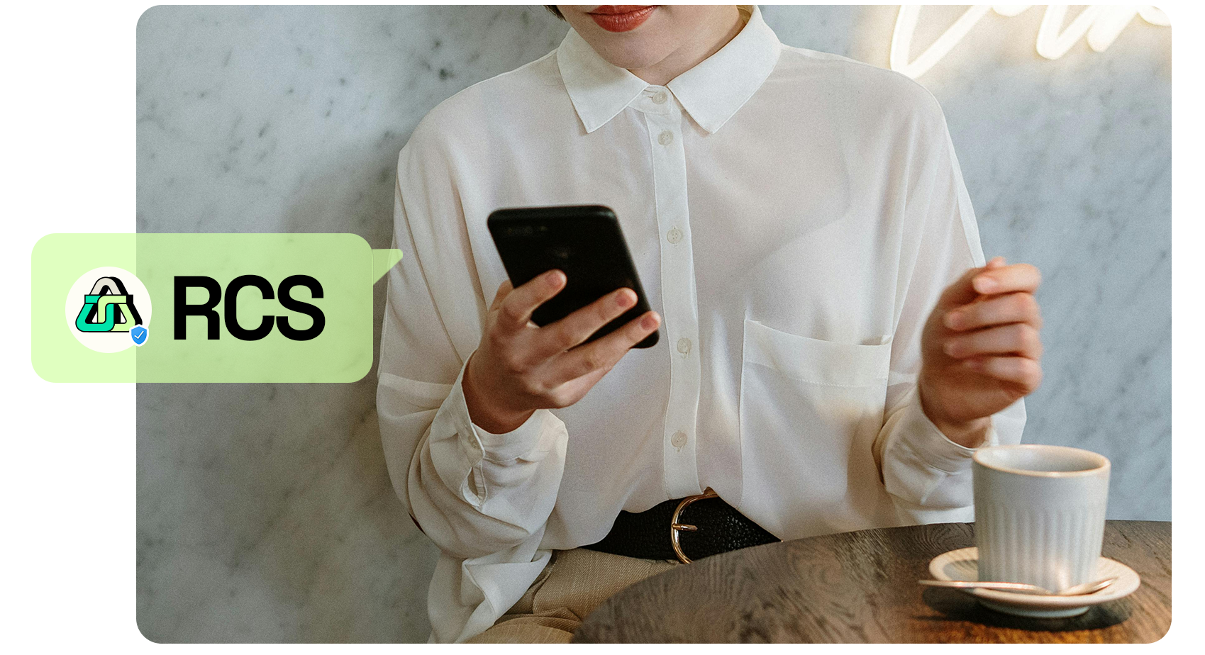 RCS image person in a cafe holding a phone