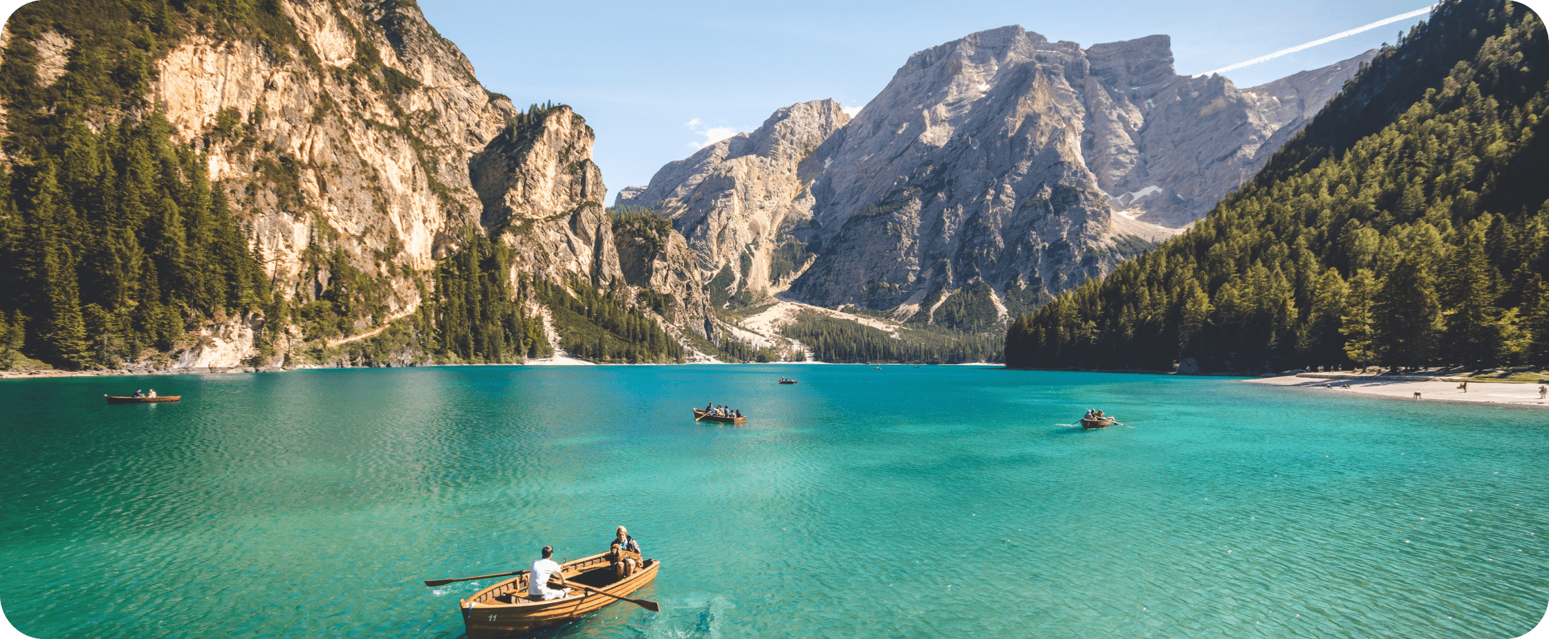 People rowboating on clear lake