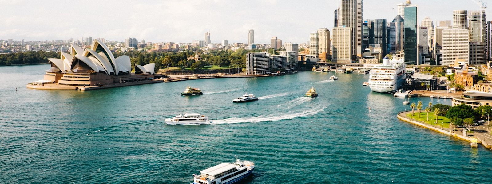 An image of Sydney Harbour. The Sydney Opera house is on the left and there are ferries in the water.