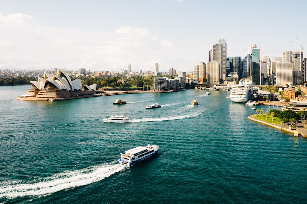 An image of Sydney Harbour. The Sydney Opera house is on the left and there are ferries in the water.