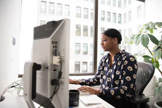 An accountant working on individual tax return forms 1040/1041 using a tax form template, in a well-lit office space.