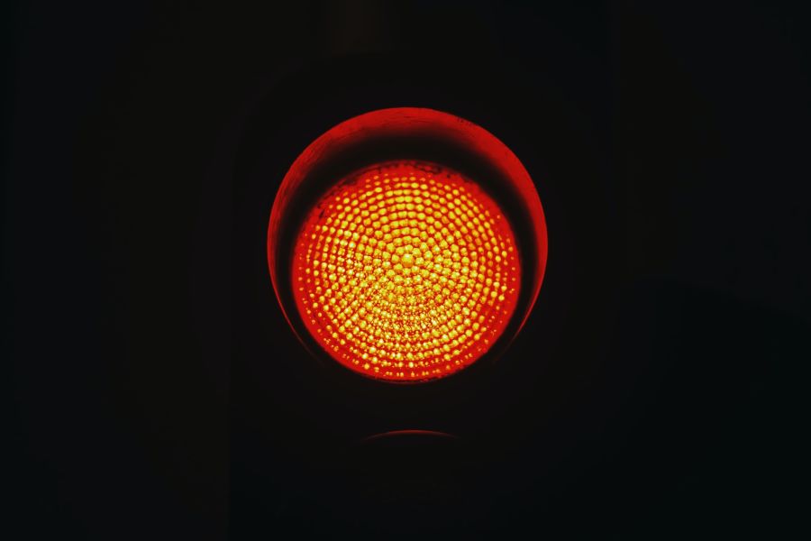 A red traffic light with a completely black background.