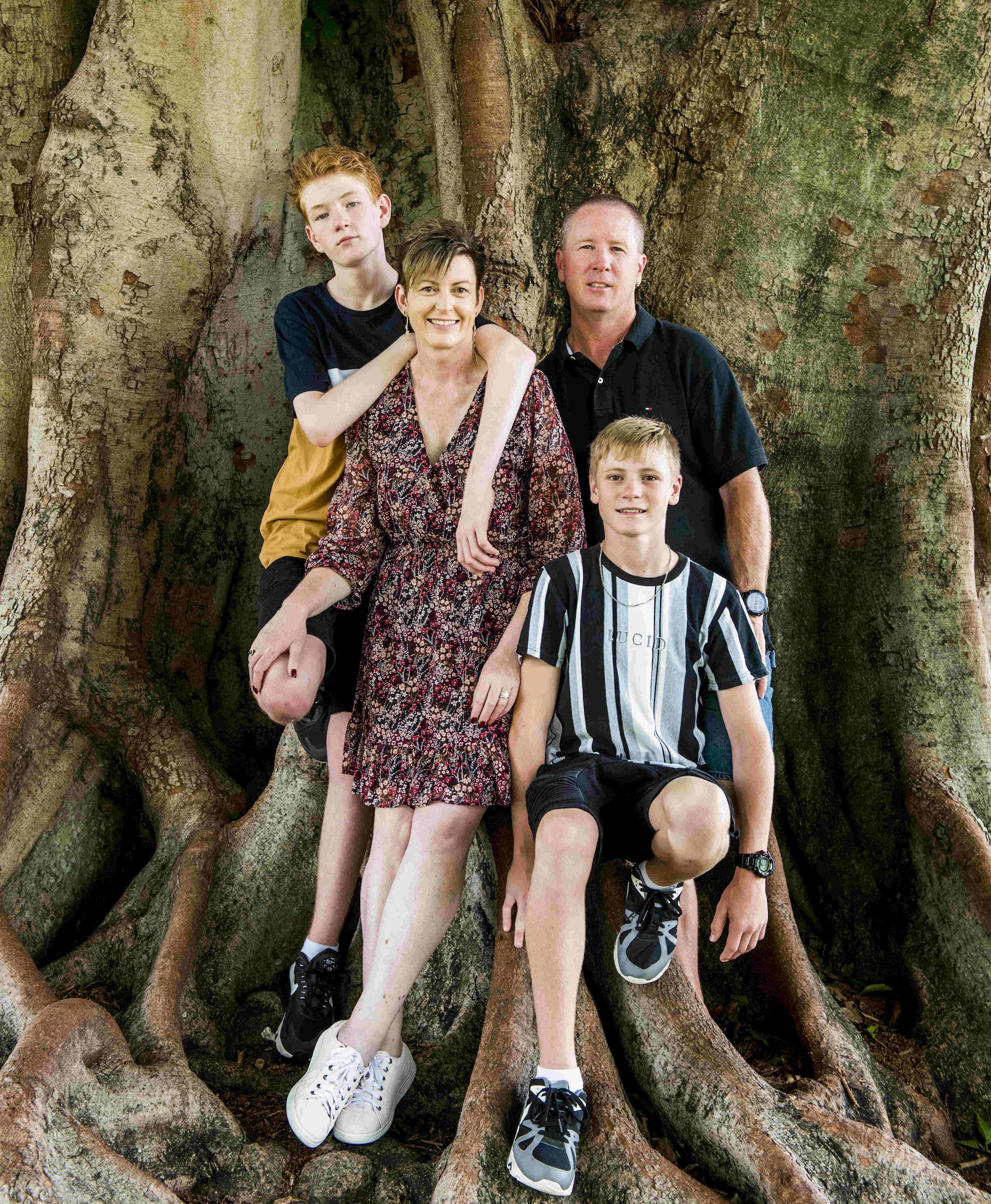 Sarah Stein, owner of Miss Efficiency, and her family. They're standing in front of the base of a huge tree.
