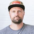 Chase Birky's headshot. He is wearing a cap and a grey tshirt and has a beard.