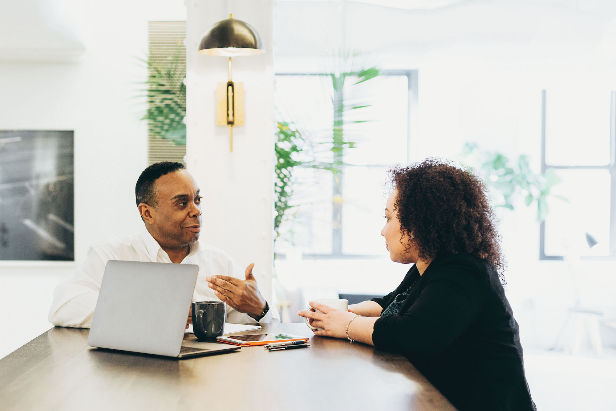 Two people are sitting around a table in deep discussion.