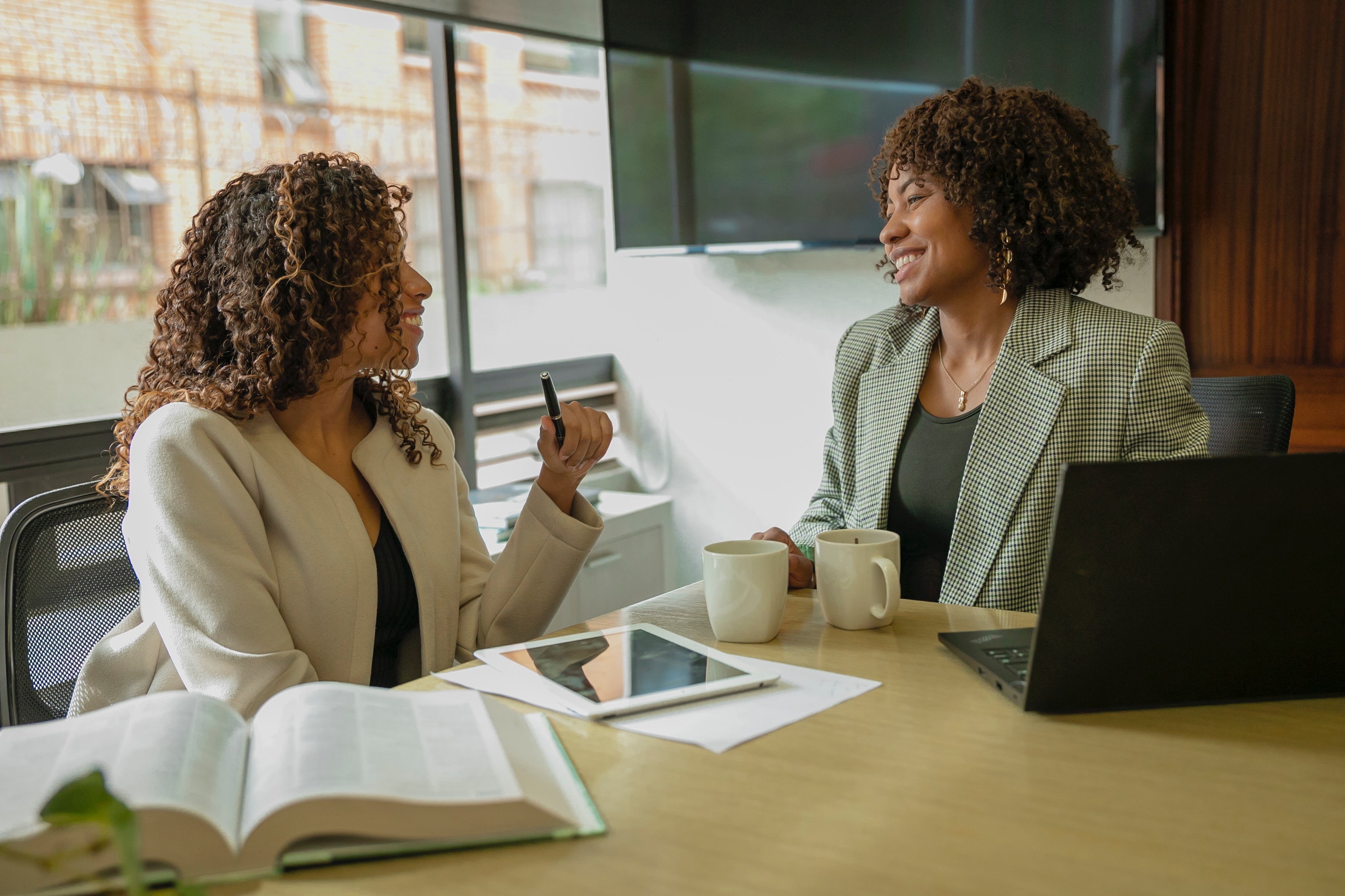 Two colleagues sitting at a desk, in discussion.