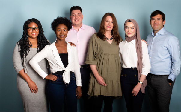 6 members of the BKL ABS team standing in front of a gray/blue wall.